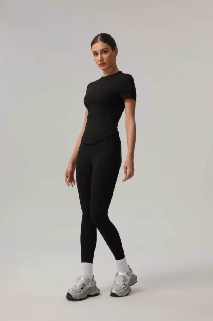Femme en mouvement portant l’ensemble Cléo noir, vue de trois-quarts