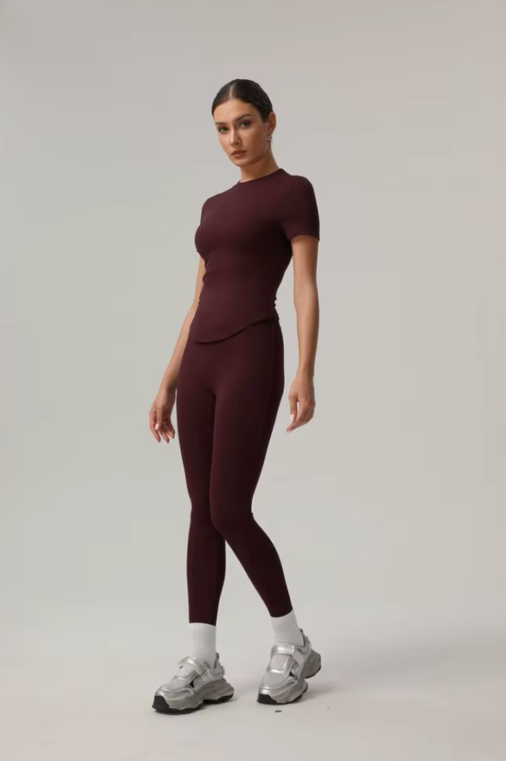 Femme posant dans l’ensemble Cléo bordeaux, de profil, sur fond neutre
