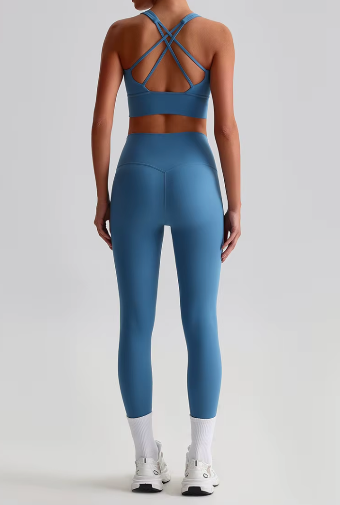 Dos de l’ensemble Rebecca bleu, avec focus sur les bretelles croisées et la coupe gainante du legging.
