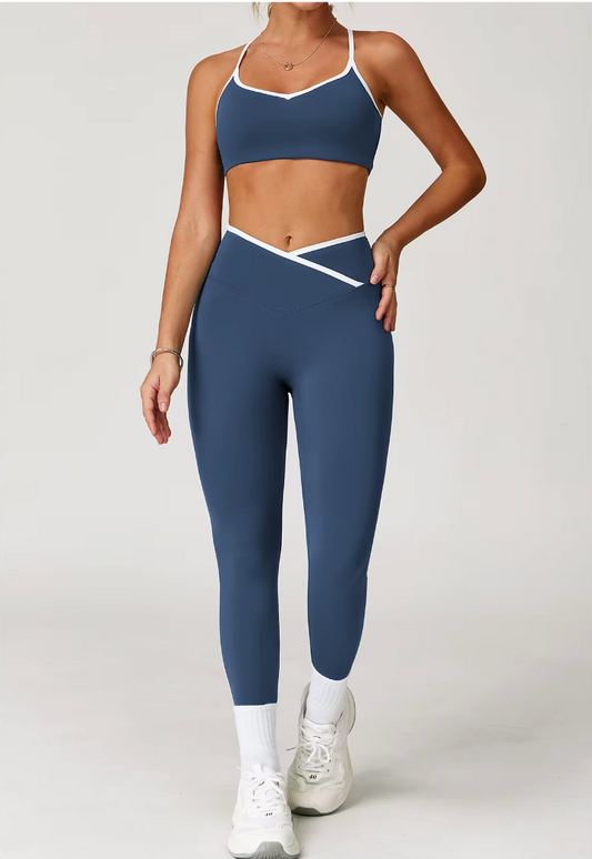 Femme portant l’ensemble Tina bleu marine avec brassière à fines bretelles réglables et legging taille haute croisée. Vue de face.