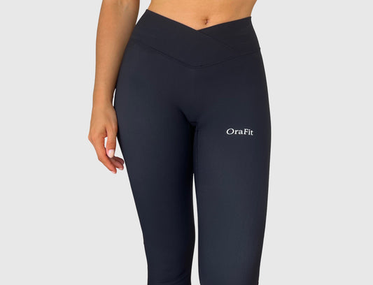Femme portant le legging Lila noir, mettant en valeur la taille croisée et la coupe épurée